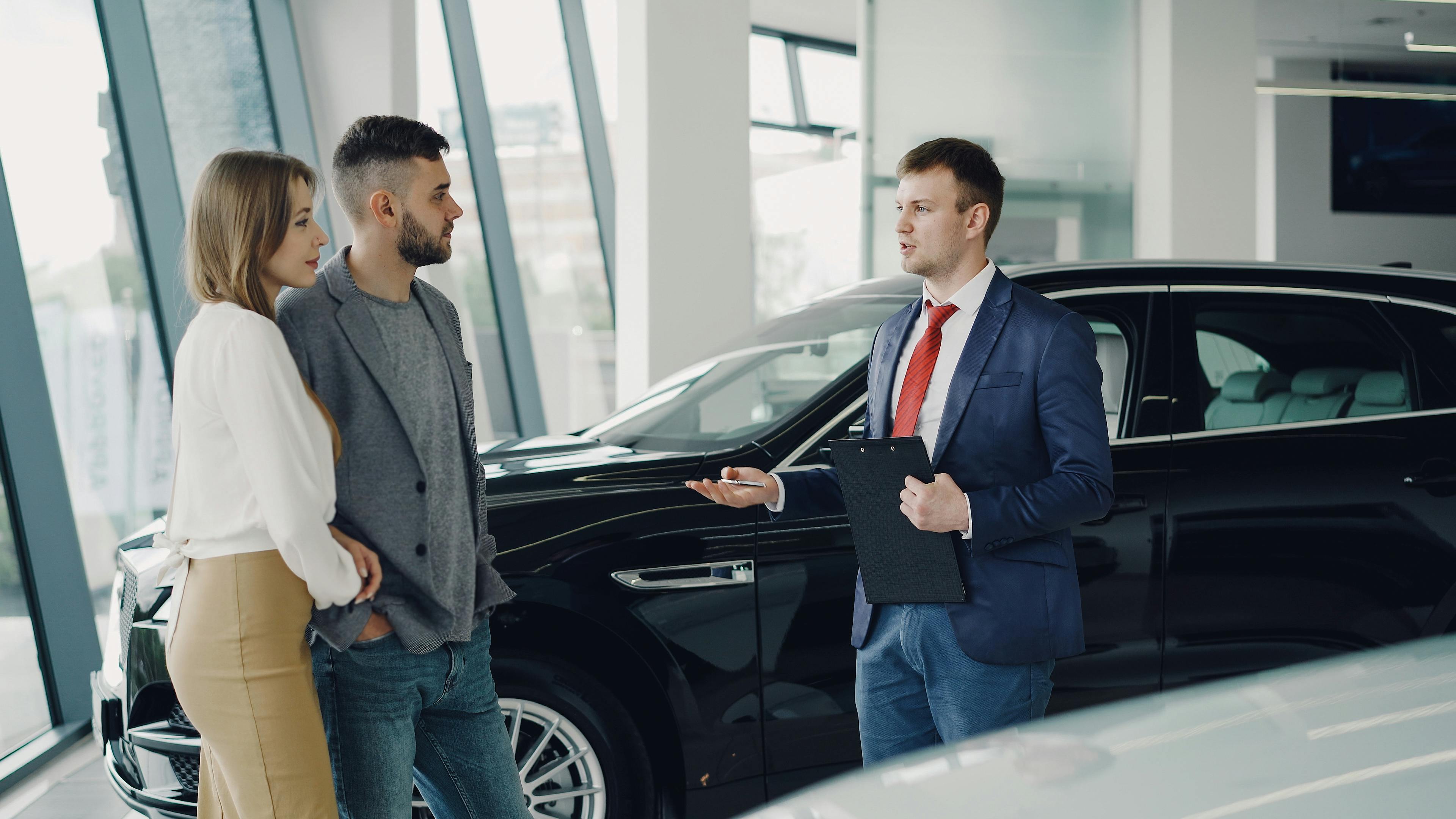 Automotive consultant speaking with customers in a dealership showroom
