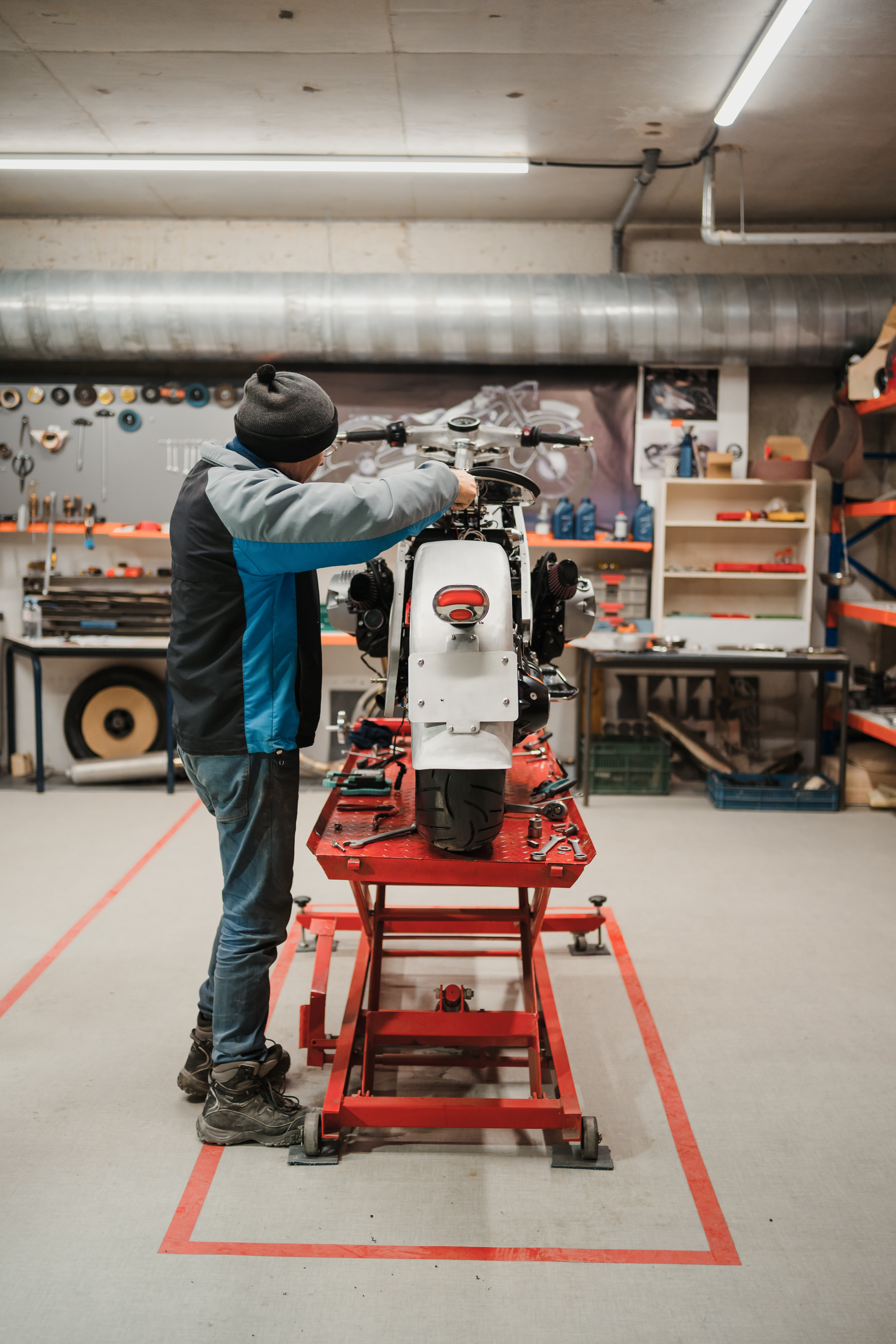 Technician repairing a motorcycle in a modern workshop